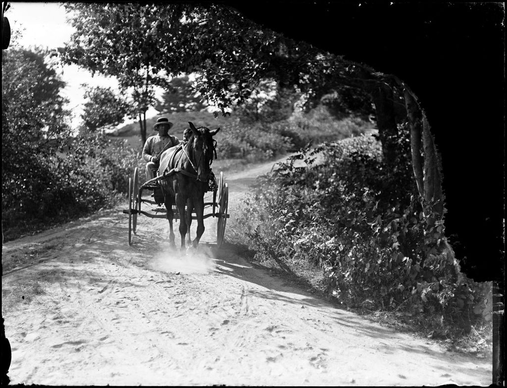 Miniature of Man And Young Boy Riding Down A Rural Road In A Horse Drawn Buggy