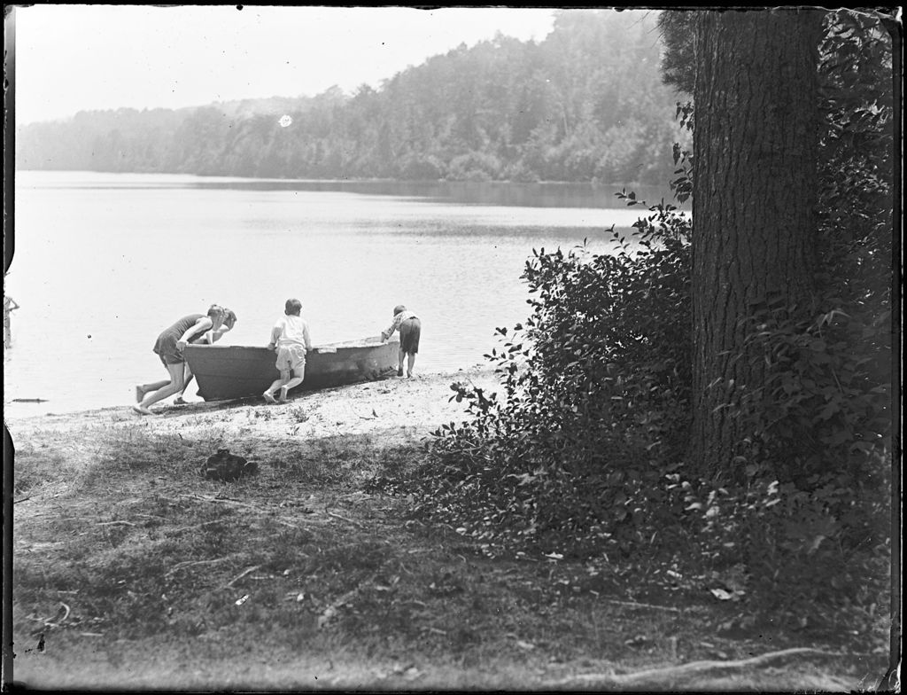 Miniature of Four Boys Trying To Push A Rowboat Into A Pond