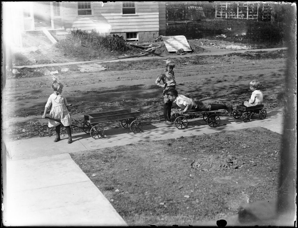 Miniature of Group Of Four Children Playing On A Sidewalk With Their Toy Wagons