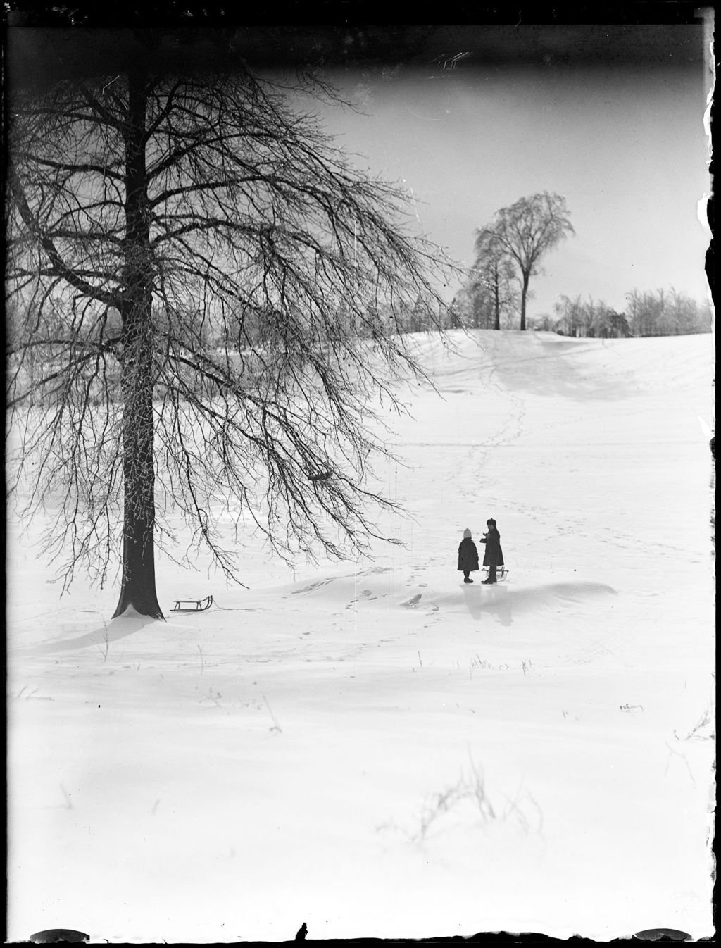 Miniature of Two Children With A Sled Standing In A Snow Covered Field