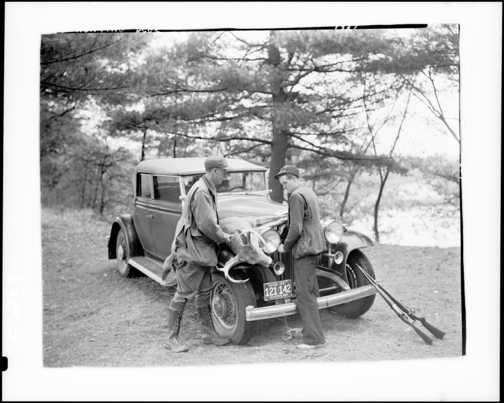 Miniature of Two Hunters Tying Deer Onto Fender Of A Car