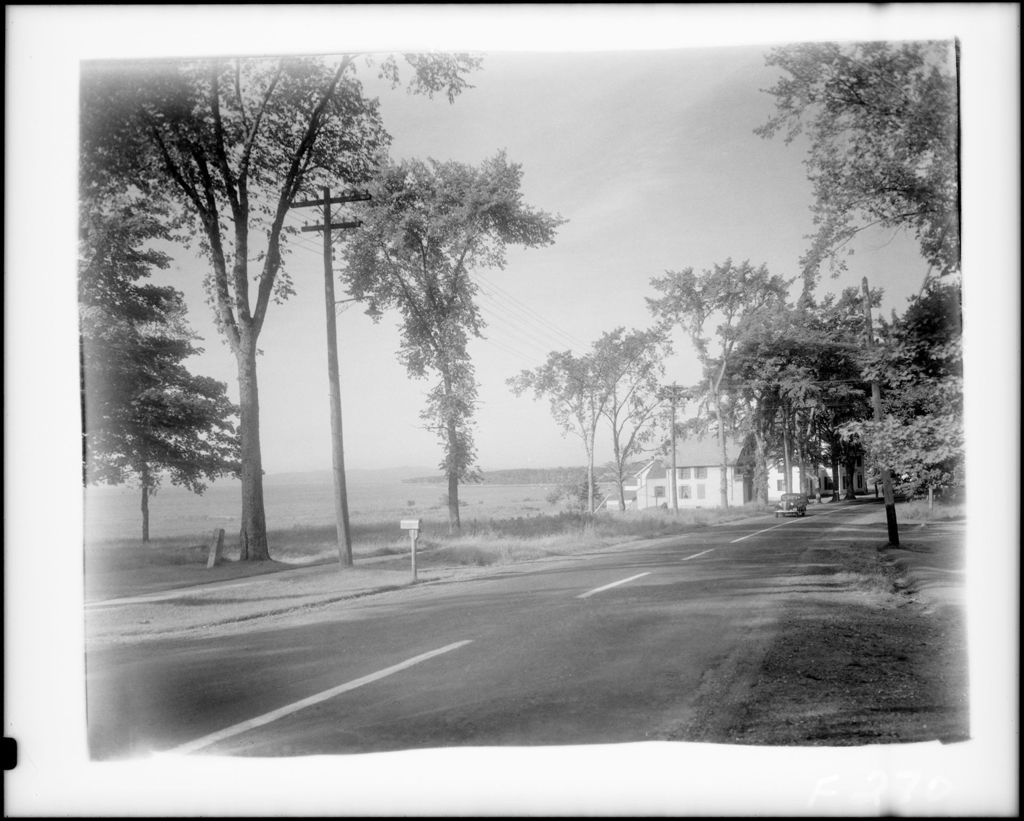 Miniature of Shot Down Road, Left To Right Water And Mountains In Background, Houses And Trees