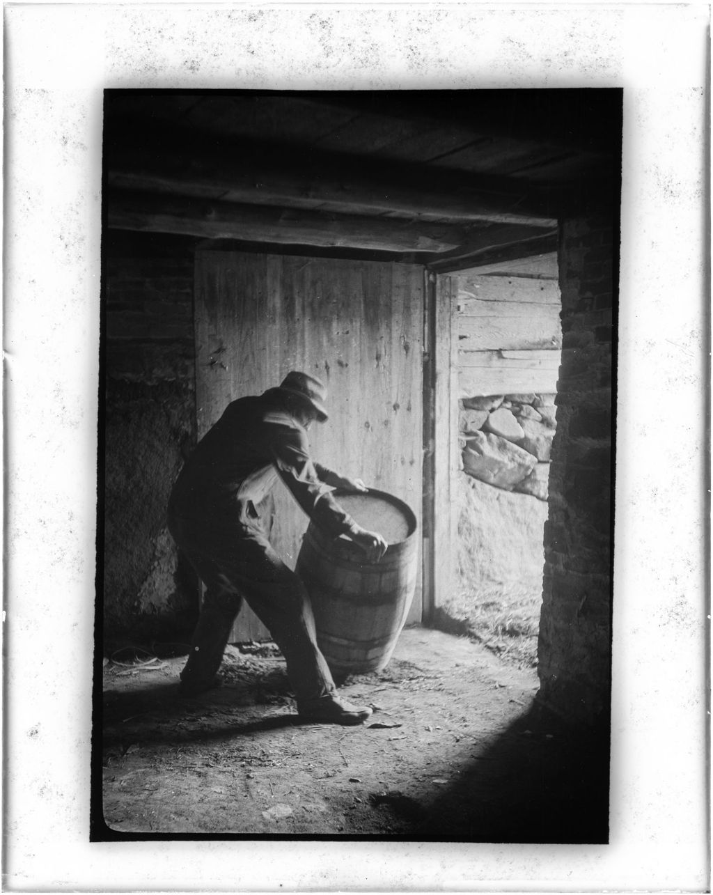 Miniature of Man Rolling A Barrel In The Doorway Of A Basement