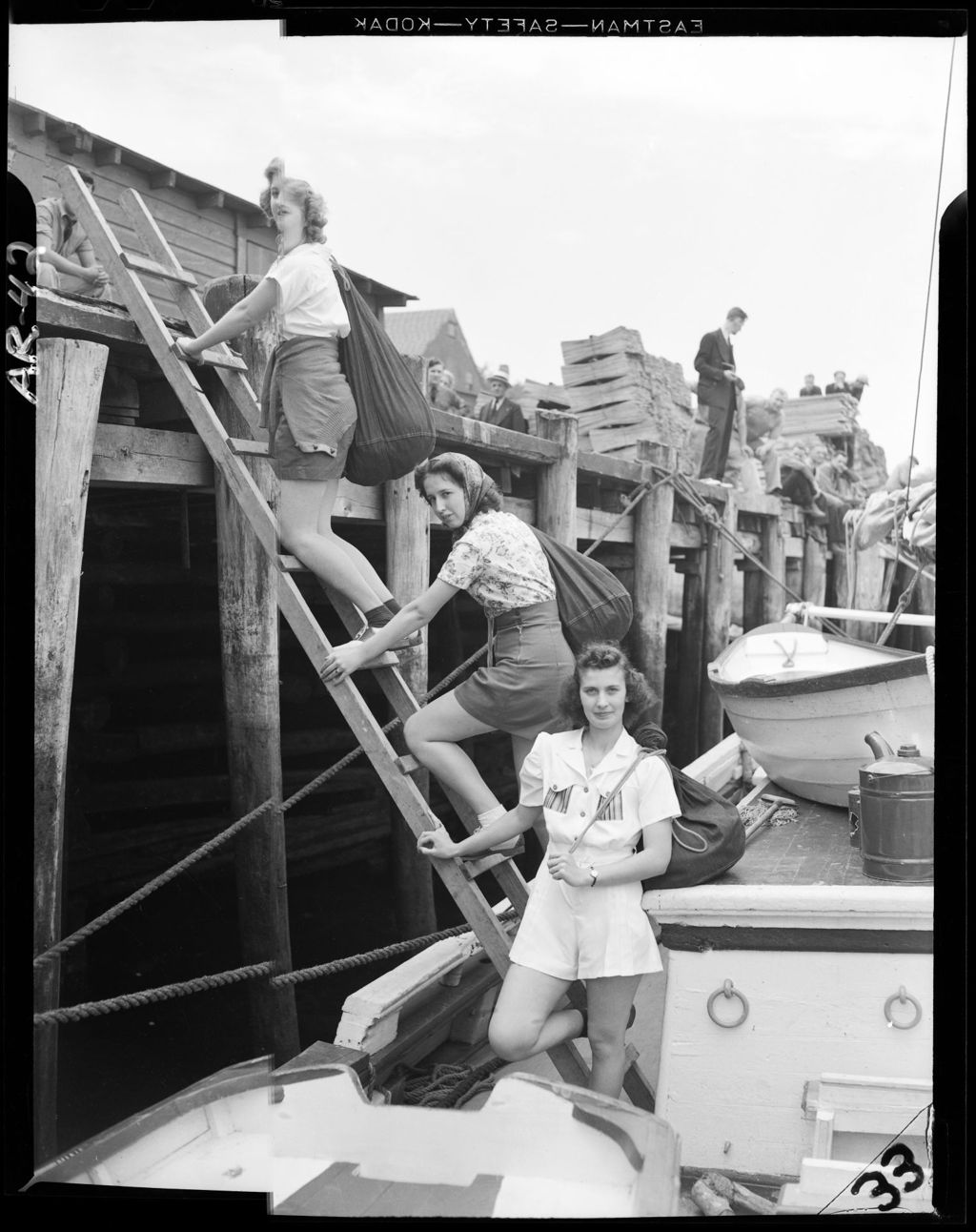 Miniature of Three Young Women Climbing Ladder On A Dock Where A Schooner Is Tied Up